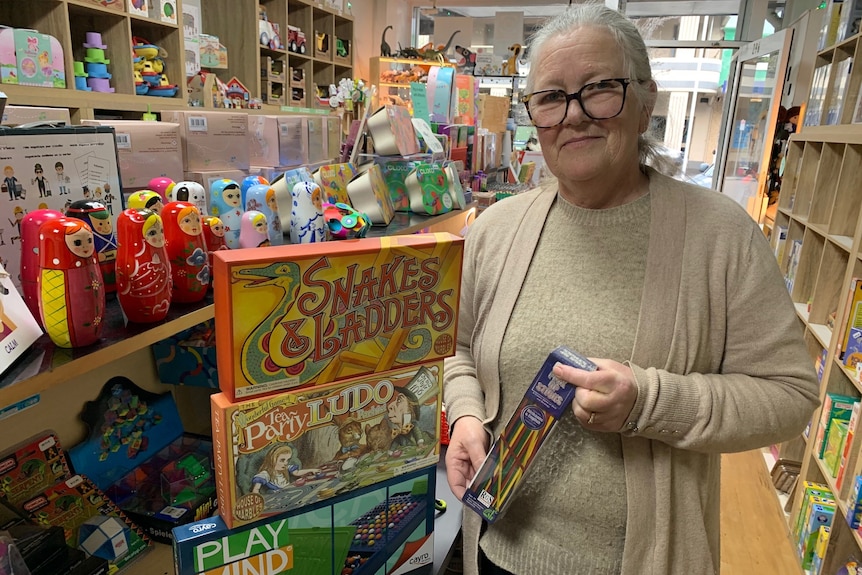 Maxine standing with a pile of classic games