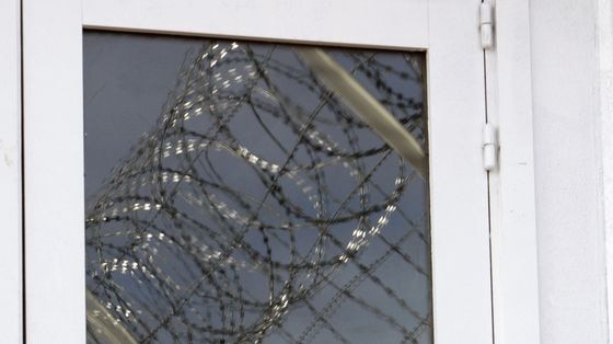 Razor wire reflects on a prison window