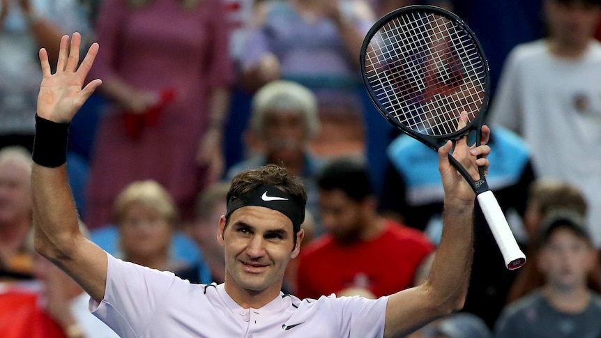 Roger Federer raises his arms in triumph after beating Jack Sock at the Hopman Cup.