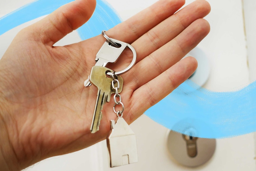 An open hand with a keys resting on it, including a house keychain, in front of a door for a story about rental applications.