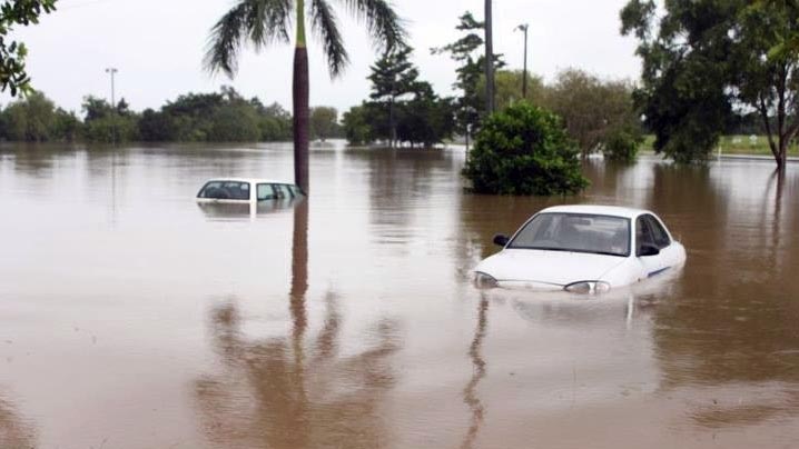 Floodwaters nearly cover two cars in Cairns on March 19.