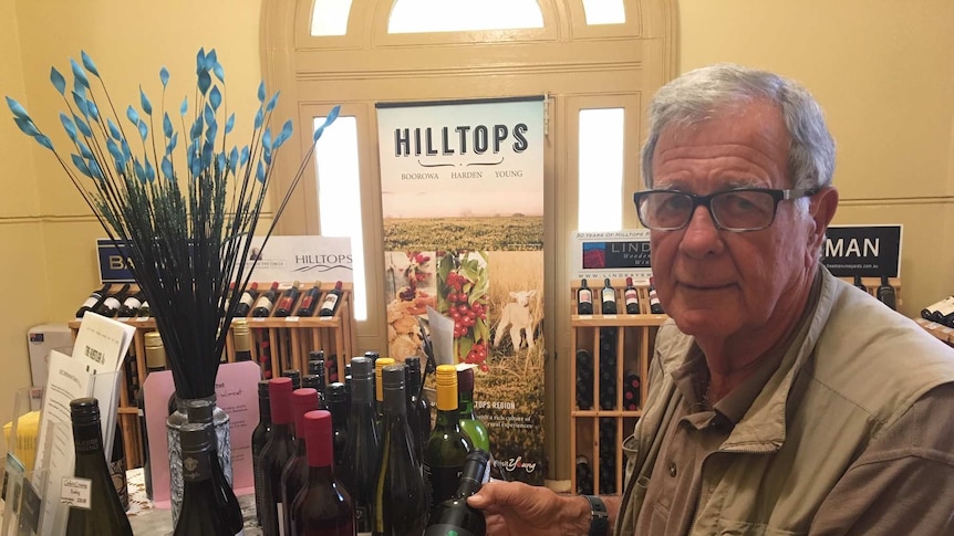 Hilltops Inc president Peter Creyke holding a bottle of wine in the regional wine centre at Young, NSW.