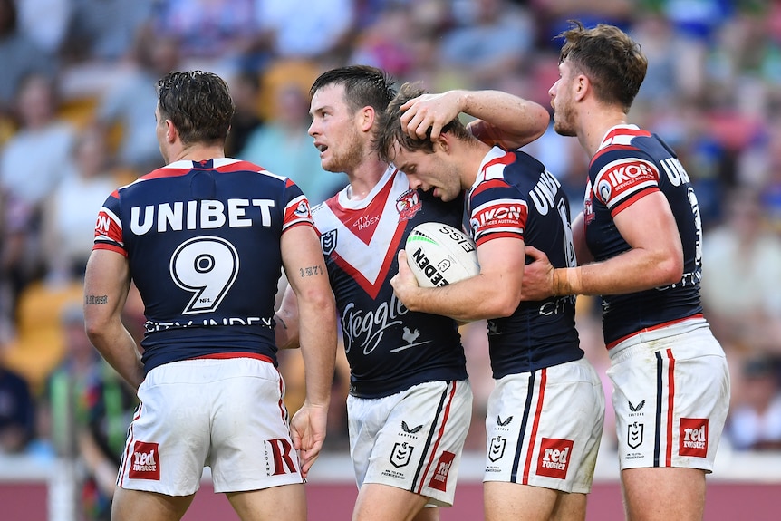Four Sydney Roosters NRL players embrace after a try was scored against Parramatta.