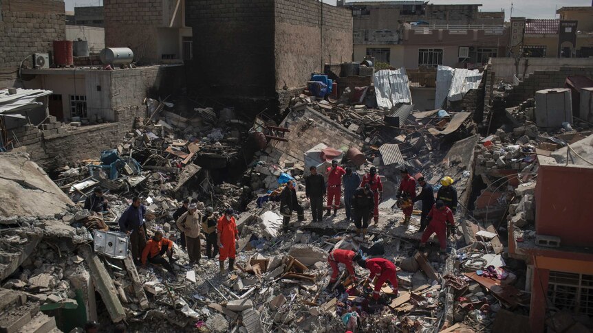 Civil protection rescue teams search through the debris of a house destroyed in a March 17 US airstrike in Mosul.