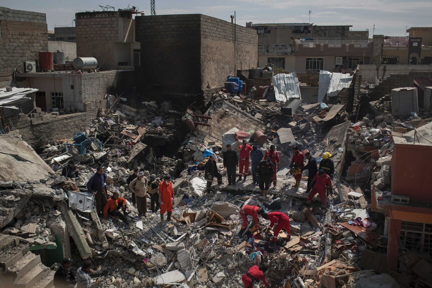 Civil protection rescue teams search through the debris of a house destroyed in a March 17 US airstrike in Mosul.