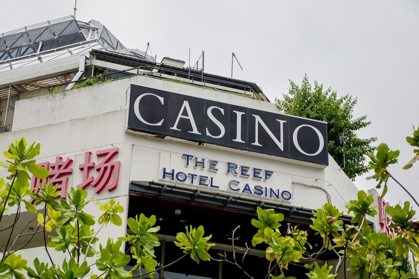 Large outdoor signage in English and Chinese on the Reef Hotel Casino in Cairns.