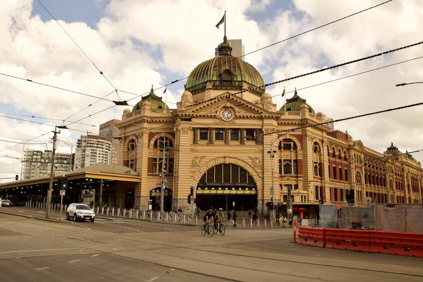 An empty city intersection with an art nouveau style building featuring a prominent dome.