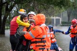 A young girl is lifted by rescue workers