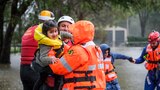 A young girl is lifted by rescue workers
