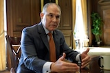 EPA administrator Scott Pruitt sits at a desk gesturing with his hands.
