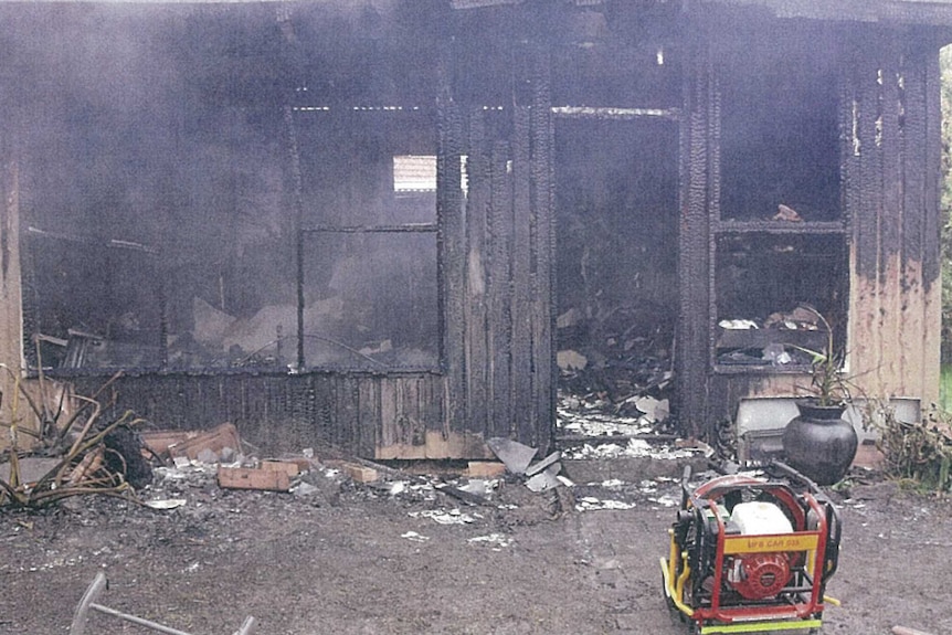 A picture of a burnt out bungalow, which is black