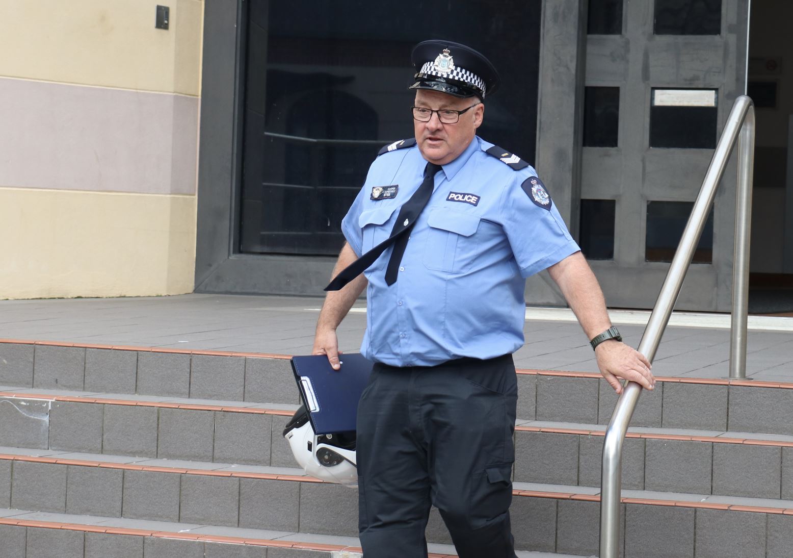 Un oficial de policía en uniforme desciende un tramo de escaleras. 