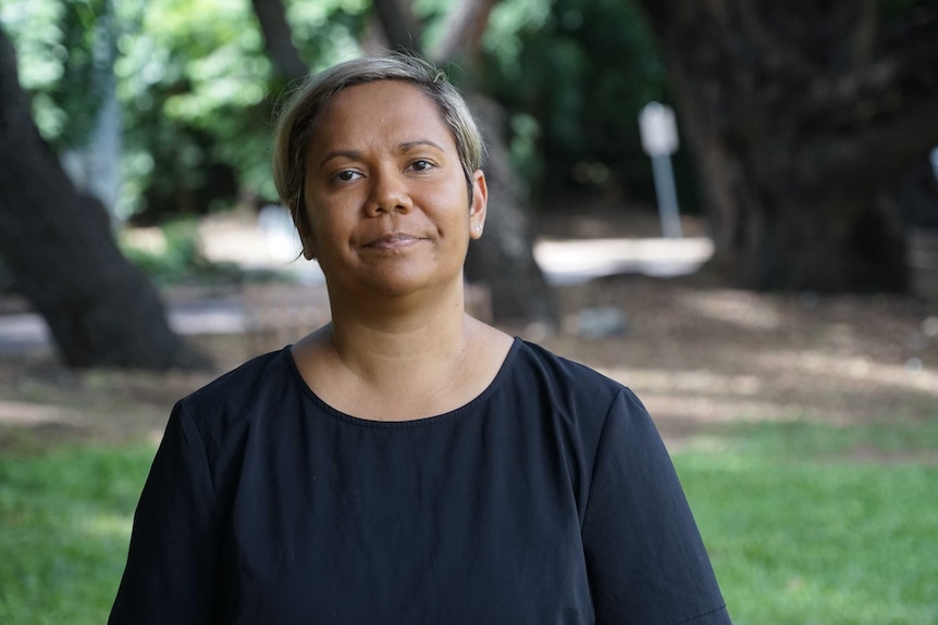 Northern Territory Attorney General looks straight ahead, while standing in a park.