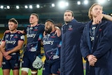 Five Melbourne Rebels players in a huddle after losing to Hurricanes in Super Rugby Pacific finals.