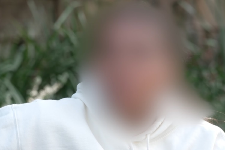 A blurred photo of a young girl wearing a white hoodie