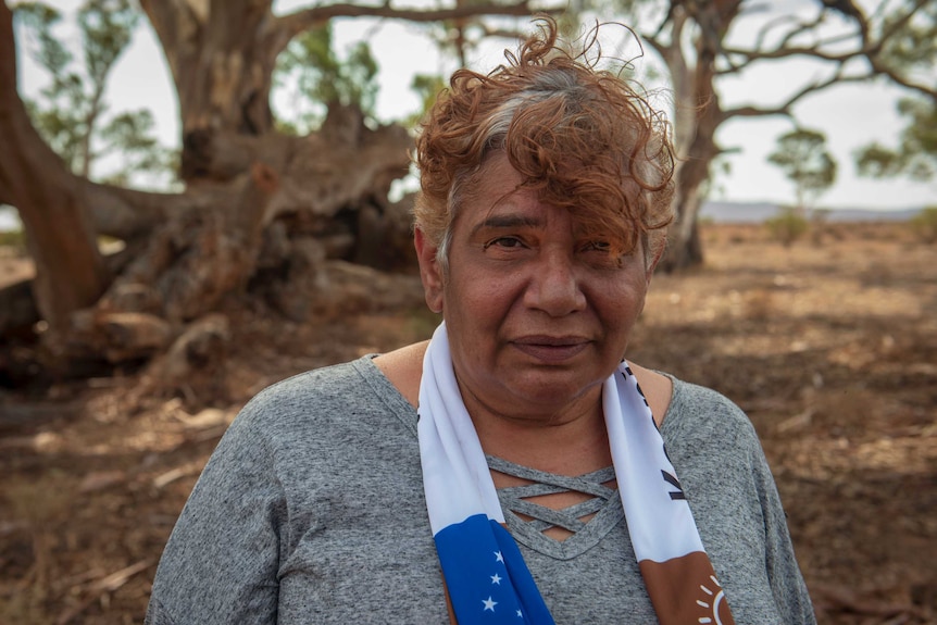 Regina McKenzie standing in front of sprawling gum trees