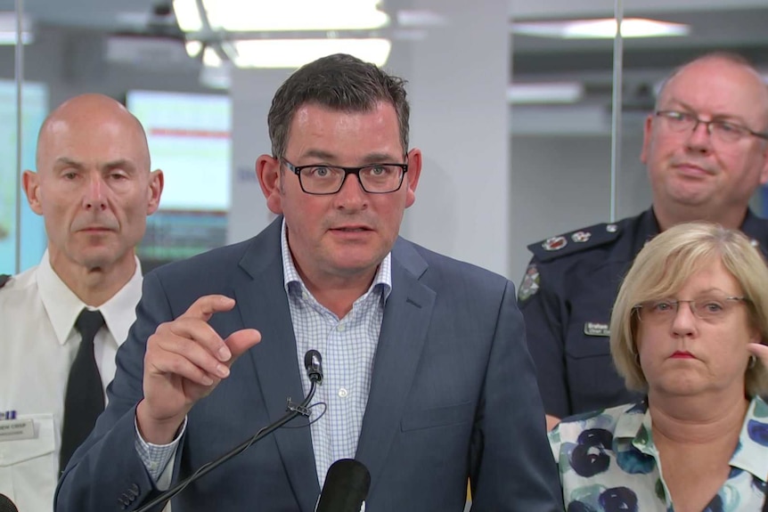 Victorian premier Daniel Andrews speaking at a podium next to emergency service chiefs and Police Minister Lisa Neville.