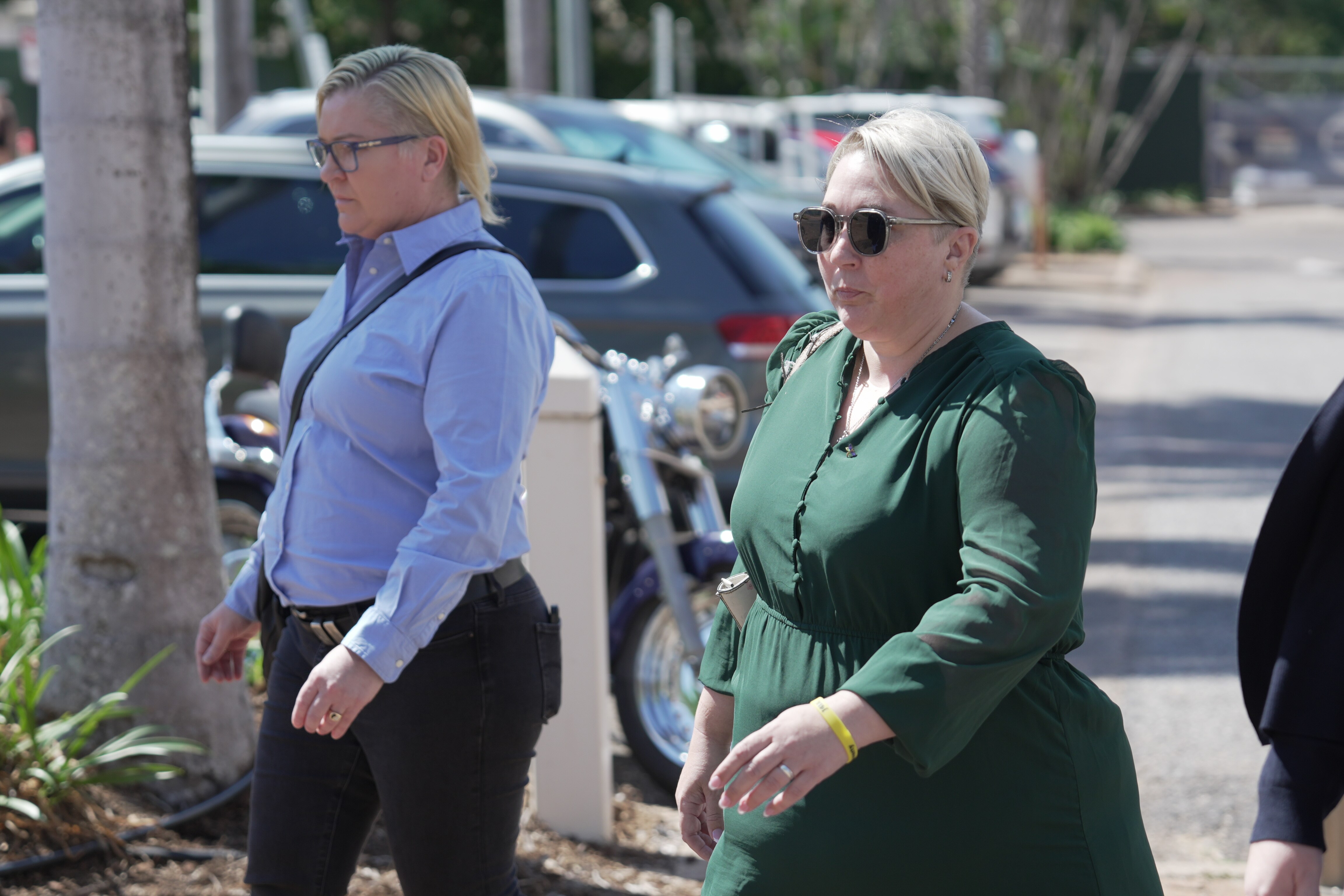 Woman in green dress walks in carpark