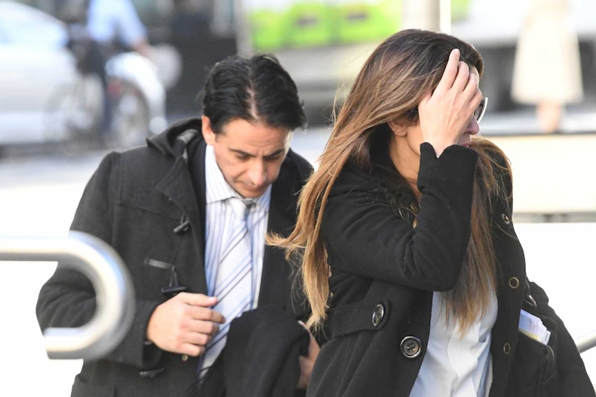 Josie Gonzalez covers her face with her hand as she walks in front of Alvaro and into the County Court building.
