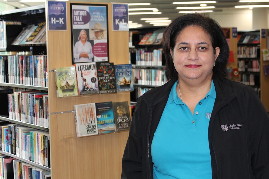 A woman standing in a library.