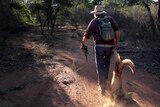 Don Sallway drags the body of a wild dog he shot after it got caught in a trap.