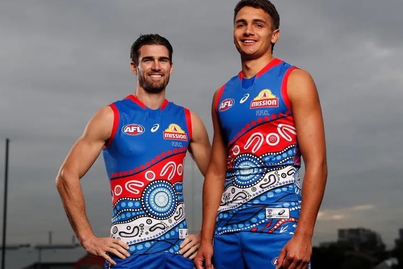 Two football players wear indigenous guernsey