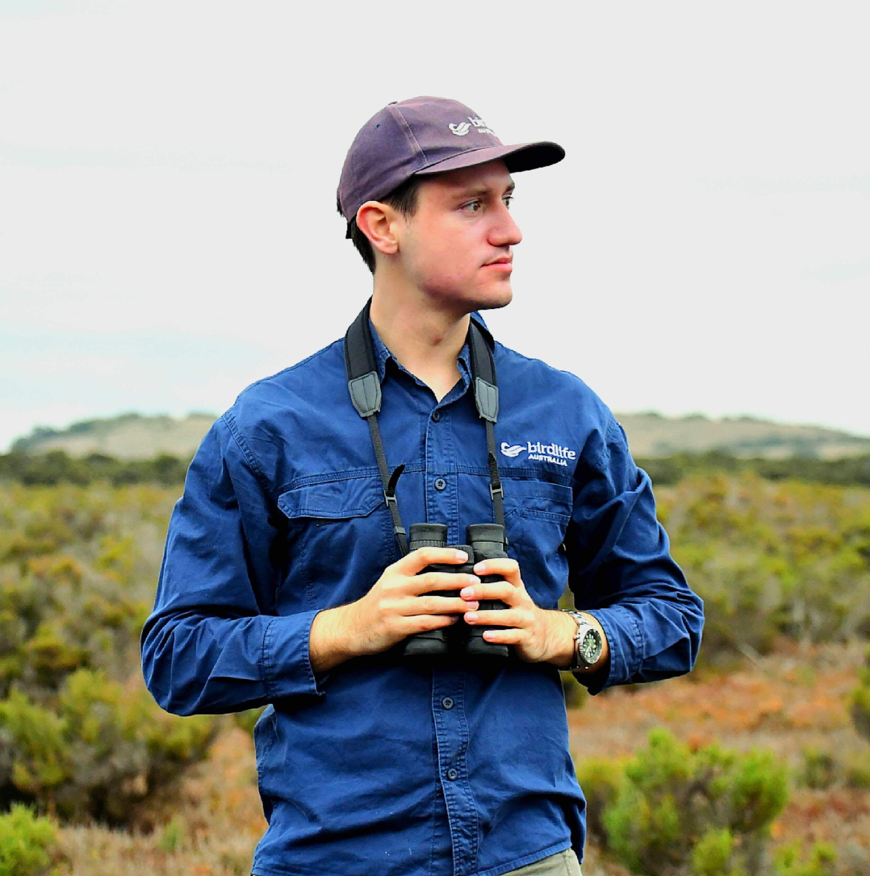 Man in wetlands with binoculars.