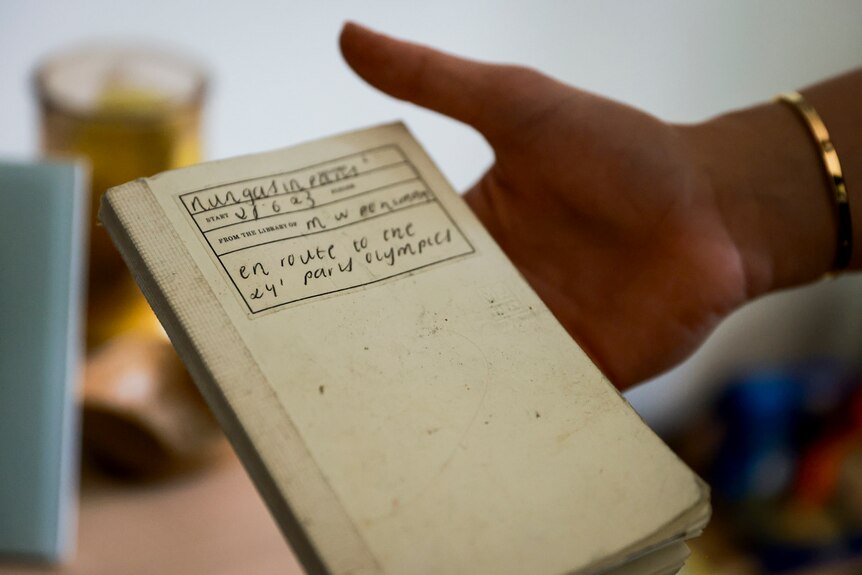 A notebook being held in the palm of a right hand.