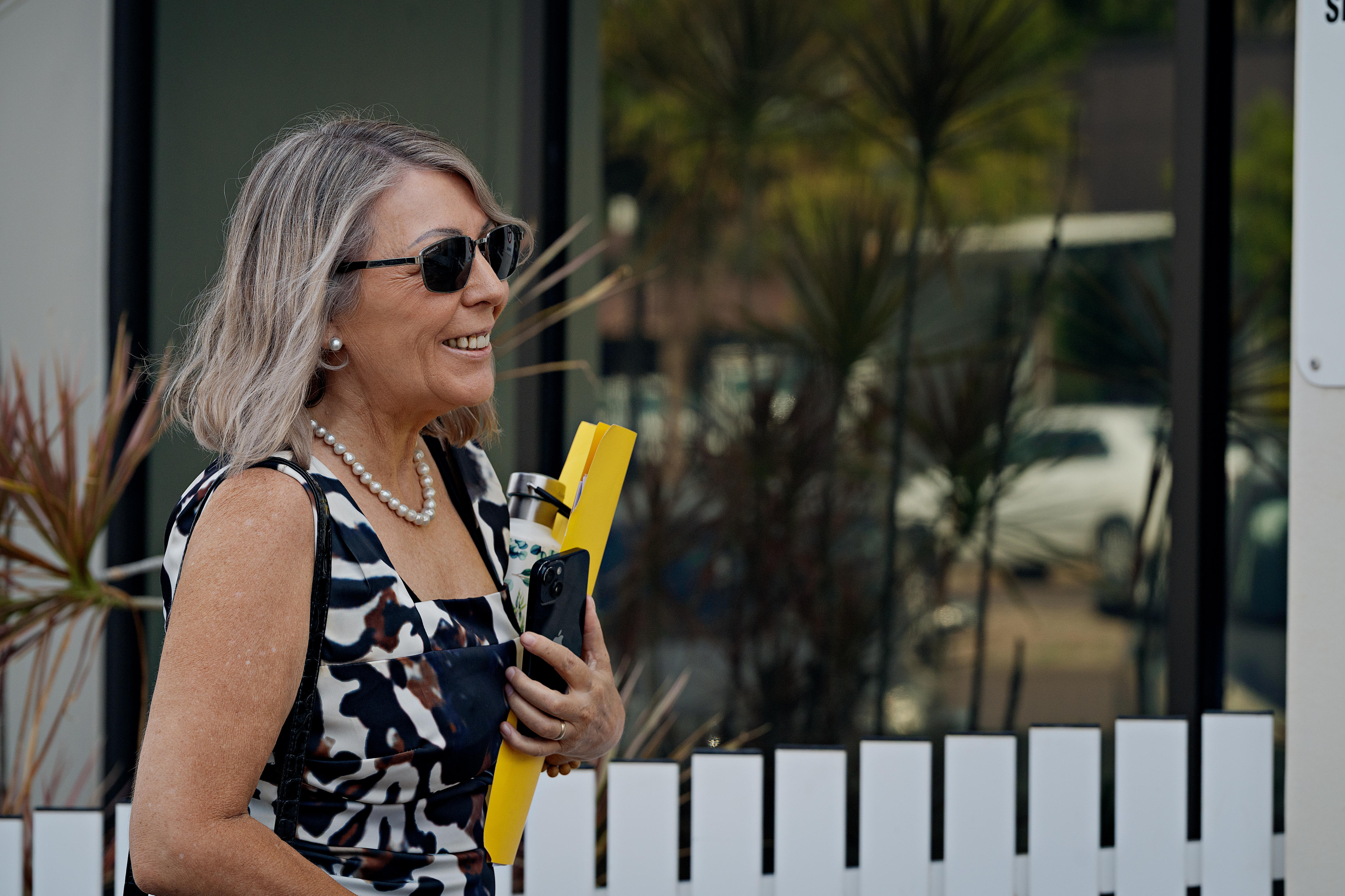 Uma mulher leva uma pasta amarela para o tribunal