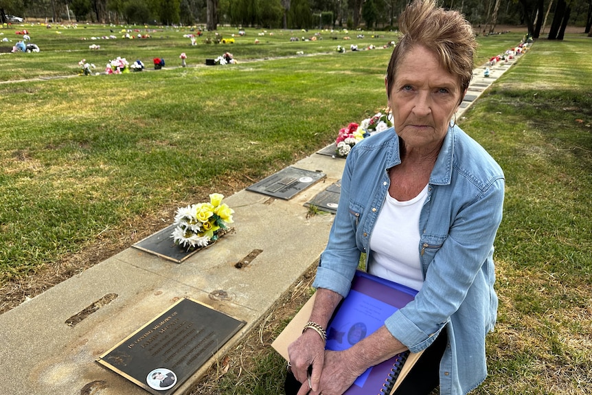 A woman sitting at the grave of her family member 