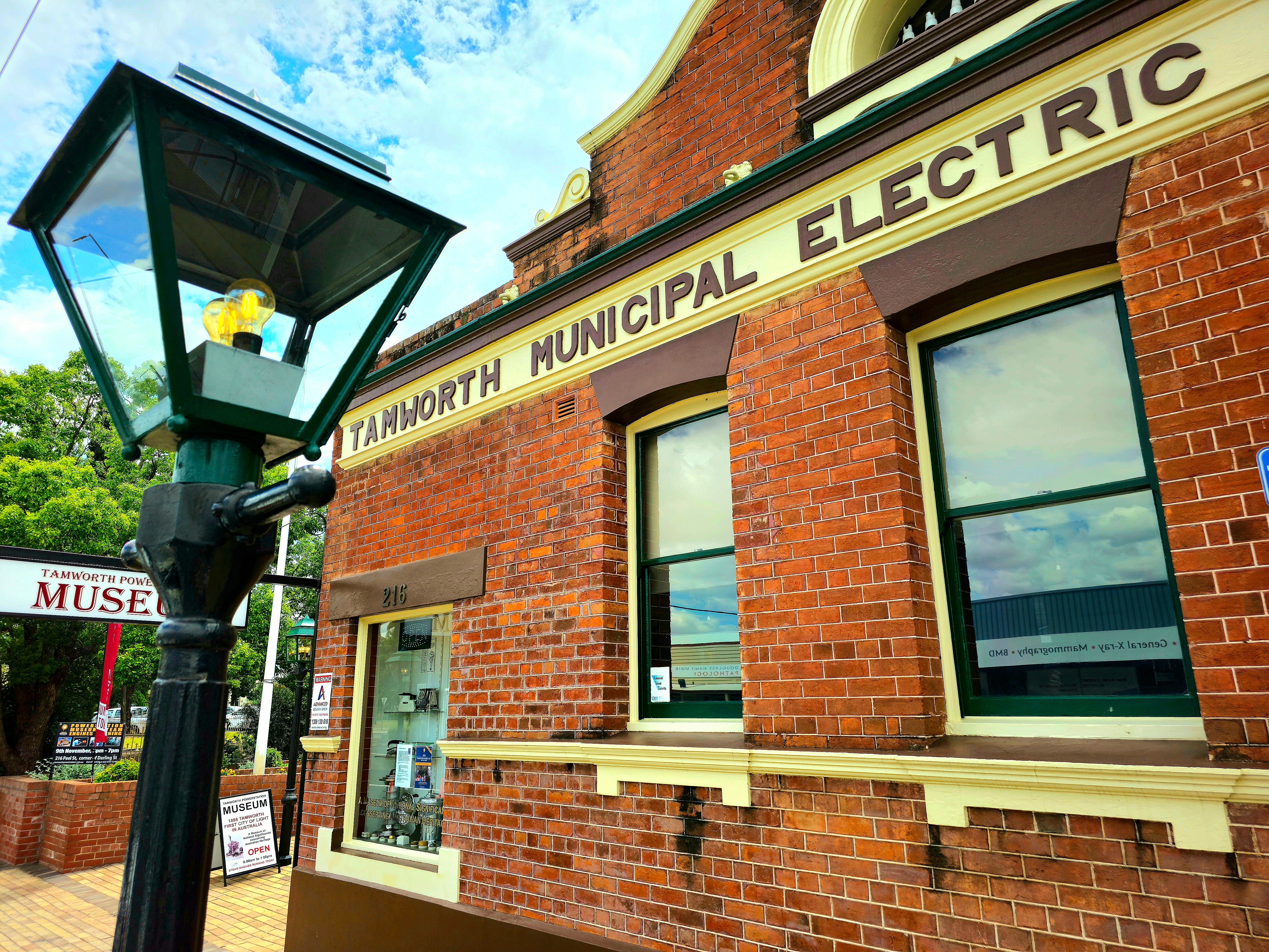 A green street light in front of a brick building