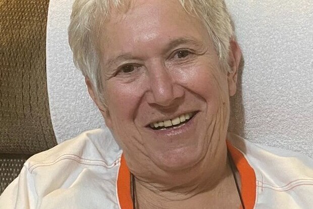 A woman with short grey hair smiles at the camera