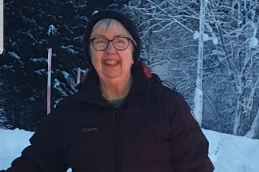 A middle aged woman in winter woolies in the snow.