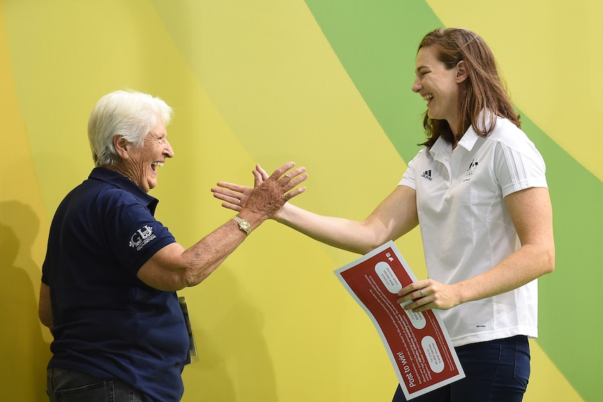 Two Australian female Olympians shake hands and share a laugh in 2016.