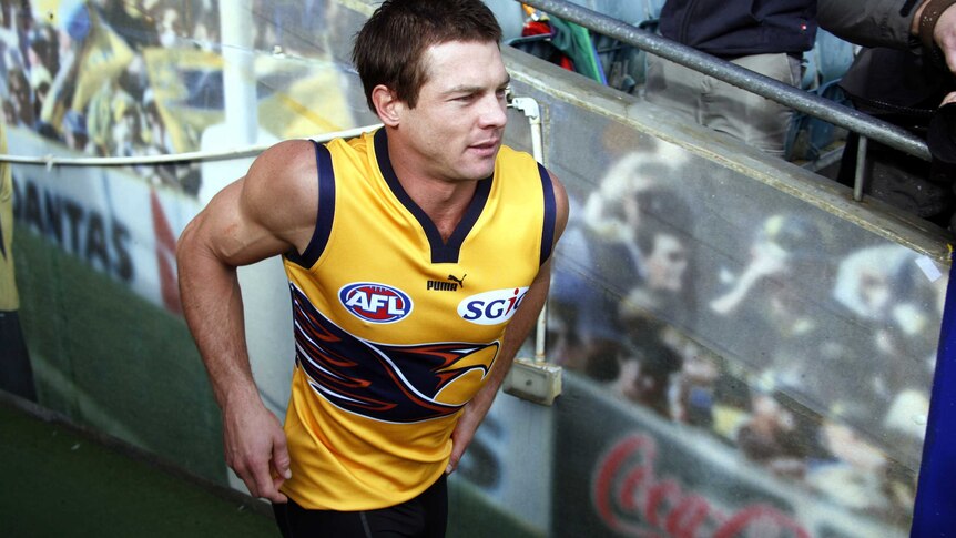 A mid-shot of Ben Cousins in a yellow West Coast Eagles training jumper running from the players' race at Subiaco Oval.