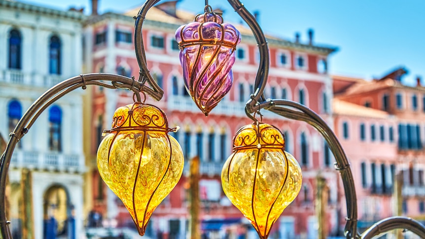 You view Venetian pink and yelow glass bulbs with renaissance Venetian buildings behind them. 