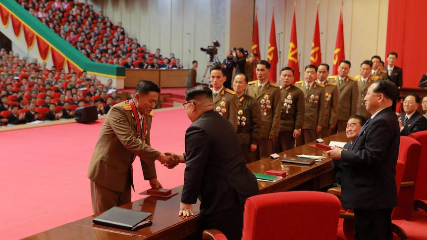 North Korean leader Kim Jong Un presents officials with medals at the 8th ammunition industry convention in Pyongyang.