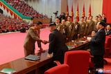 North Korean leader Kim Jong Un presents officials with medals at the 8th ammunition industry convention in Pyongyang.