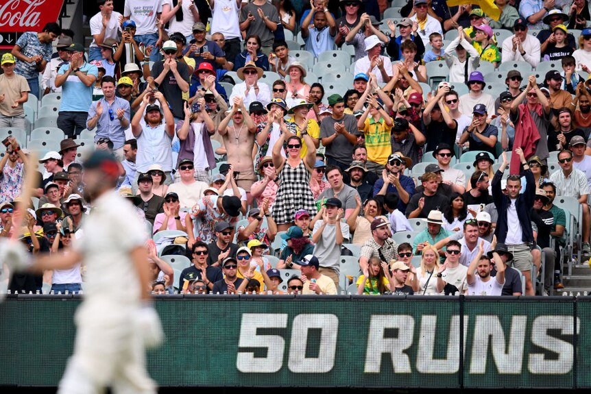 The MCG crowd cheers Mitch Marsh for making 50 runs in a Test against Pakistan.