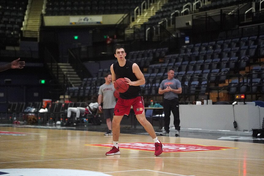 Justinian Jessup shapes to shoot a basketball at Hawks training.