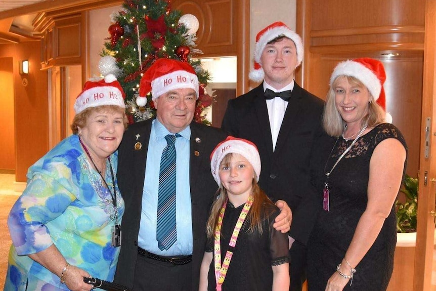 Karla and Graeme Lake and three members of their family wear Santa hats