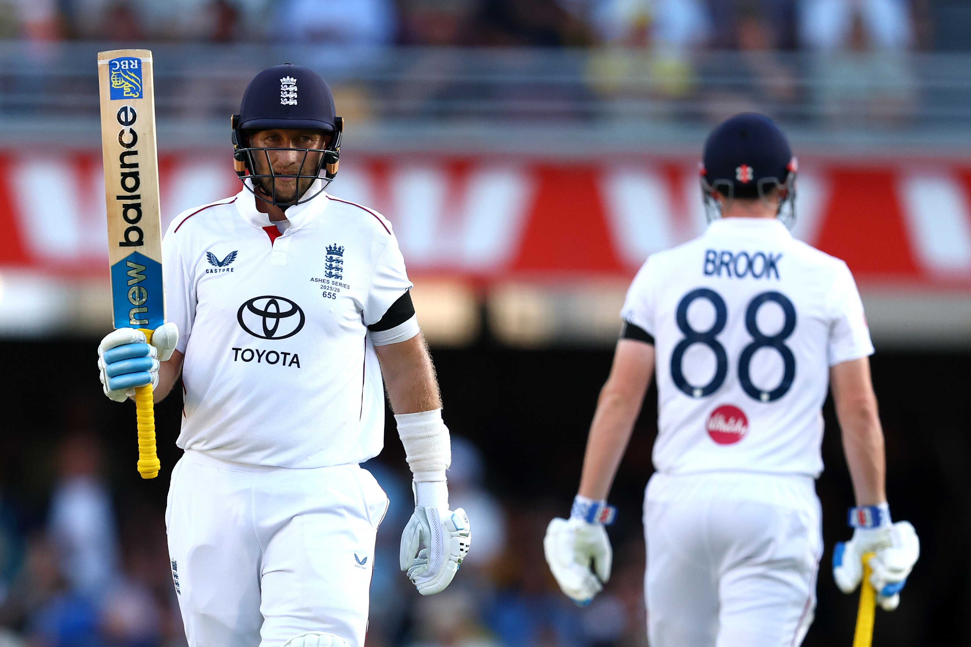 Joe Root raises his bat after making a 50