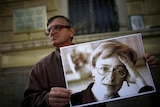 A protester holds a picture of murdered Russian journalist Anna Politkovskaya