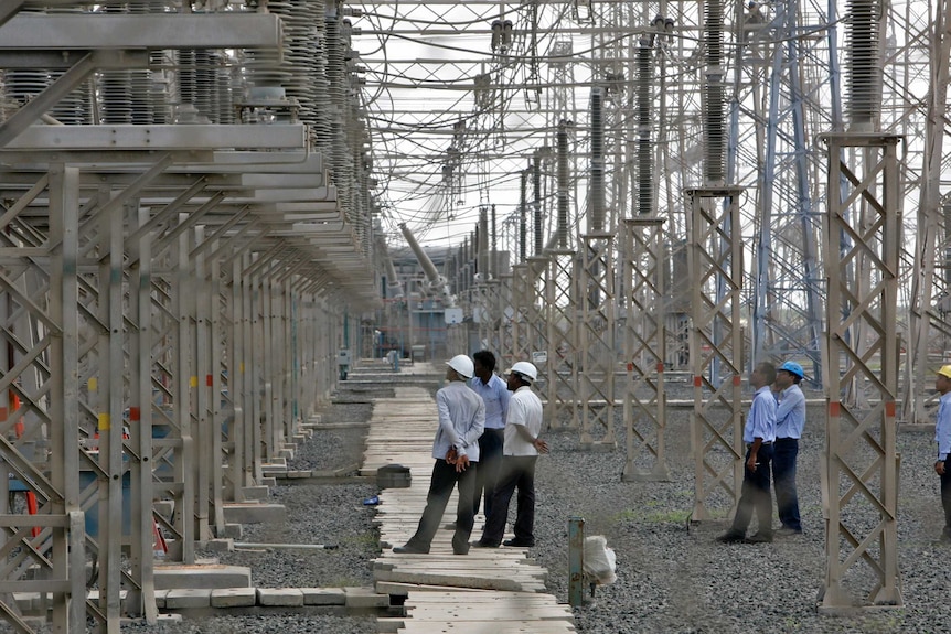 Engineers inspect electric transmission lines at Adani's thermal plant in the state of Gujarat.