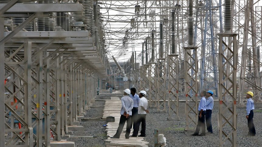 Engineers inspect electric transmission lines at Adani's thermal plant in the state of Gujarat.