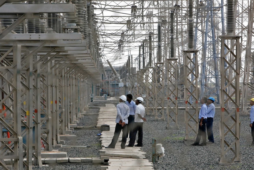 Des ingénieurs inspectent les lignes de transmission électrique de la centrale thermique d'Adani dans l'État du Gujarat.