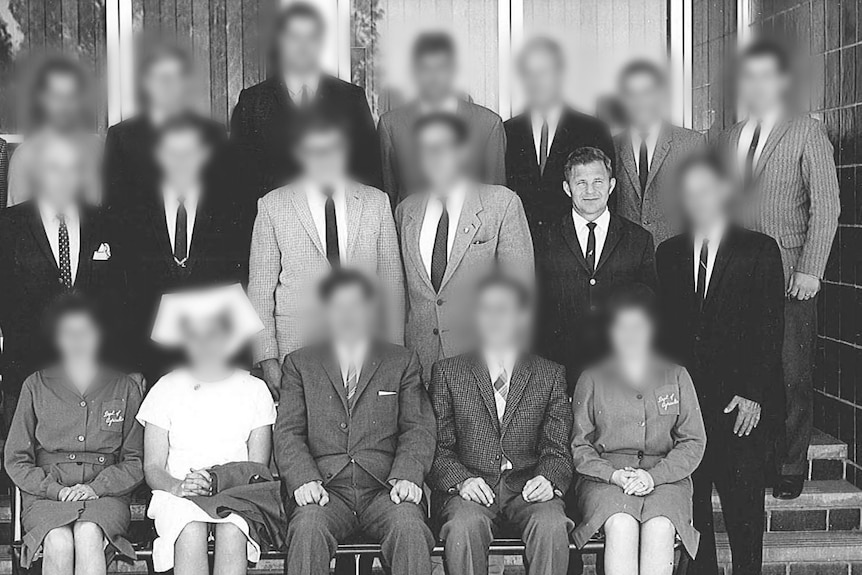 A black and white photo of a group of men with all but one of their faces blurred.