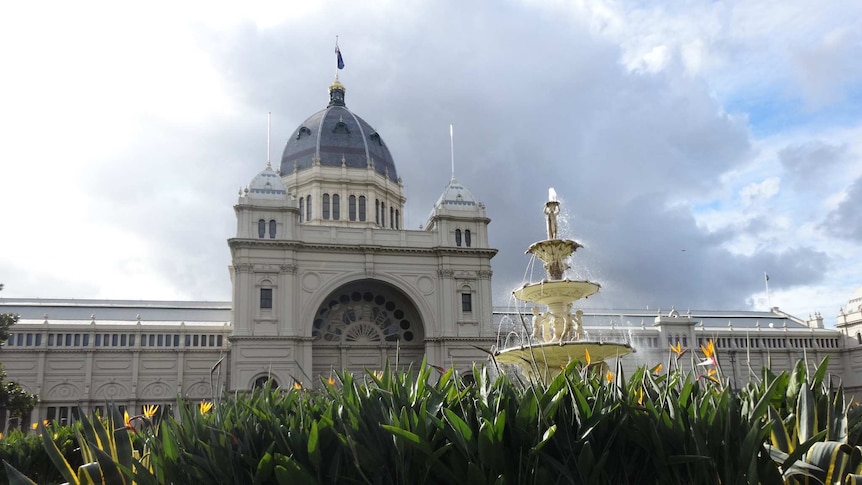 Large white building with blue dome, fountain and gardens in front