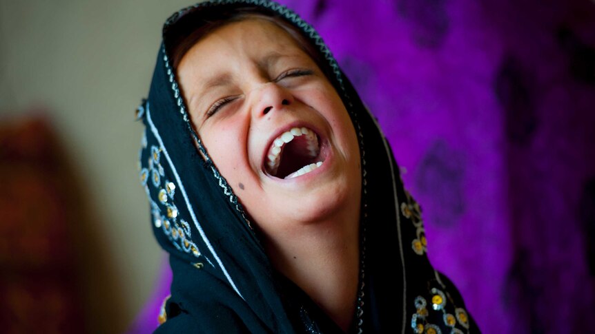 A young Afghan refugee laughs