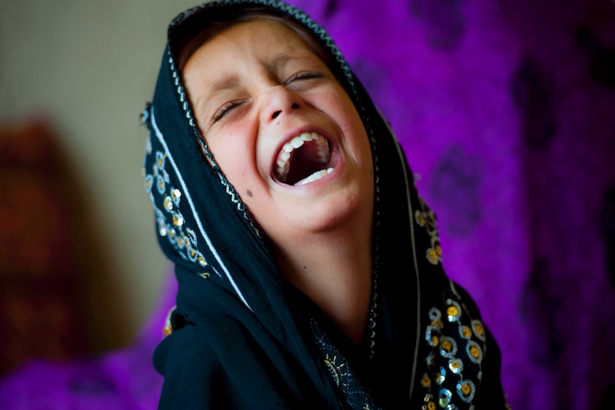 A young Afghan refugee laughs